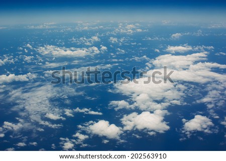 White clouds in a blue sky. Aerial view from airplane.