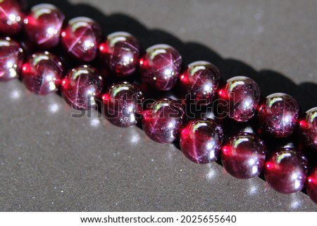 A faint star effect is visible on the surface of the pyrope garnet. Royalty-Free Stock Photo #2025655640