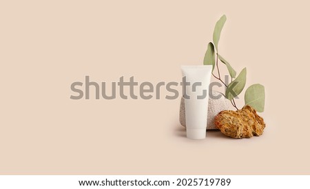 Composition from the natural materials and cosmetics tube near it.Copy space for text or design.Can be used as advertising banner.Pastel colors.Mockup concept,large banner.