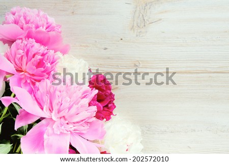 colorful peonies on white wooden surface