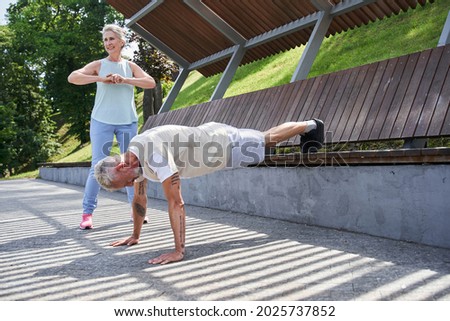 Senior couple training together at the summer park and feeling healthy