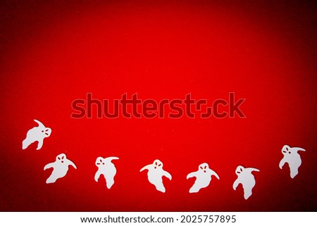 Halloween on a red background. Silhouettes of ghosts on red. Copy space. Greeting card mockup.