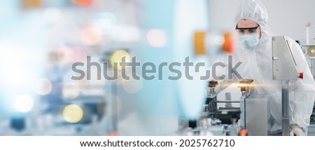 Scientists wearing protective clothing Inspect mask making machines in a laboratory at an industrial plant. Anti-virus production warehouse. concept of safety and prevention coronavirus covid-19. Royalty-Free Stock Photo #2025762710