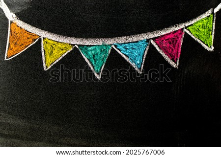 Colorful chalk handdrawing in hanging party flag shape on blackboard or chalkboard background with copy space