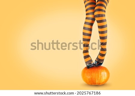 Women's legs in striped stockings on a pumpkin. tinting