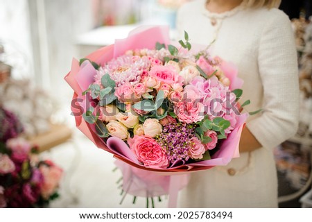 great bouquet of pink chrysanthemum hydrangea and roses wrapped in paper in woman hands. Floral shop concept. Handsome fresh bouquet. Royalty-Free Stock Photo #2025783494