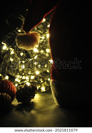 Christmas festive background with lights, ribbons and santa hat.