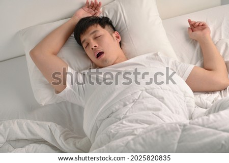 Young Asian man sleeping and snoring loudly lying in the bed
 Royalty-Free Stock Photo #2025820835