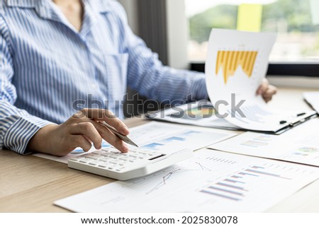 A female financier is reviewing company financial documents, monthly financial statement summary from the finance department. The concept of managing the company's finances for accuracy and growth. Royalty-Free Stock Photo #2025830078