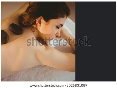 Composition of woman lying on towel with stones on her back over black background. health and wellbeing template concept digitally generated image.