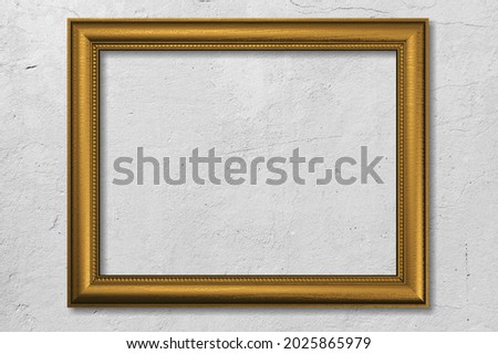 picture frame. The wooden gold frame on a wall background