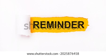 On a bright yellow background, white paper with a torn stripe and the inscription REMINDER. Royalty-Free Stock Photo #2025876458