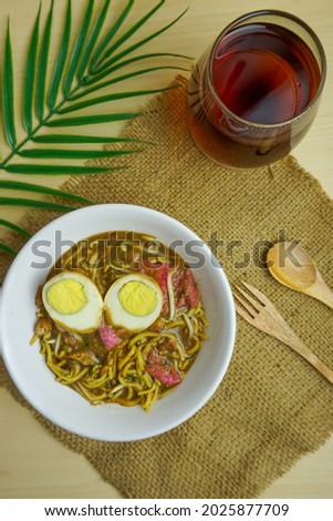 Special boiled noodles or "Mie Rebus" from Medan, North Sumatra, Indonesia with yellow noodles, egg, bean sprouts, shrimp crisp, and sweet and savory sauce Royalty-Free Stock Photo #2025877709