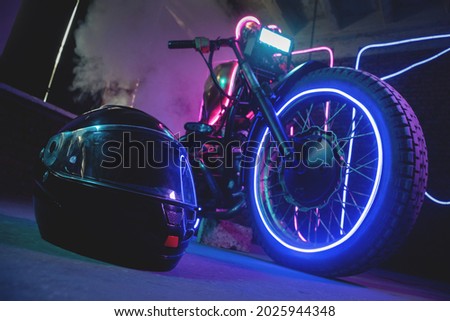 Black motorcycle helmet in the neon lights. Motorbike store showroom concept. Royalty-Free Stock Photo #2025944348