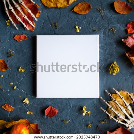 Halloween concept. Blank canvas frame and Halloween decoration on dark background. Mockup poster. Top view.