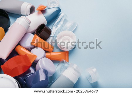 Used plastic packaging for cosmetics on a blue background. Trash with used cosmetics plastic packagings. High quality photo Royalty-Free Stock Photo #2025964679