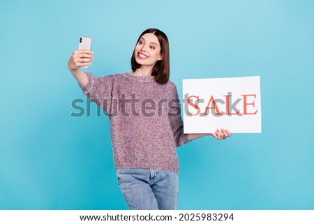 Photo of cheerful blogger lady hold phone sale placard take selfie wear pullover isolated blue color background