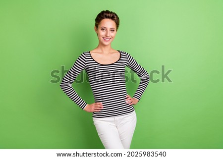 Photo of charming young pretty nice woman hold hands waist lady smile isolated on green color background