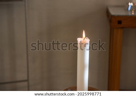 Single lit candle light in a church.