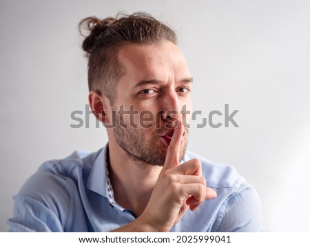 White Young Man Makes Secret, Silence, Shh Sign Confidently