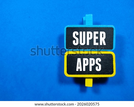 Business concept.Text SUPER APPS writing on colored wooden board on blue background.