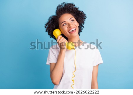 Photo of cheerful excited smiling african girl look copyspace dreaming talk on phone isolated on blue color background