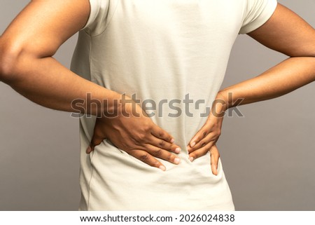 Close up of african woman suffering from back pain, arthritis, radiculitis. Black female having muscle or chronic nerve pain in spine after working. Posture disorder, scoliosis, osteoporosis concept