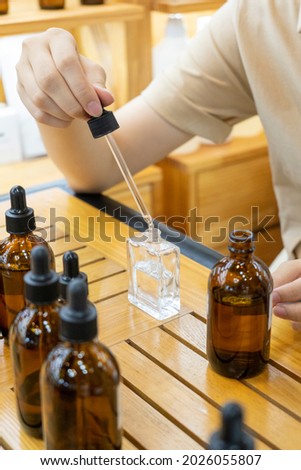 Woman mixing ingredients to make perfume 