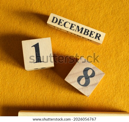 December 18, Wooden Calendar cube on yellow felt fabric for date icon background.