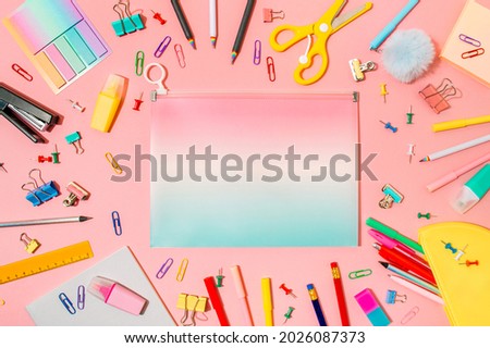 Creative student desk with school supplies and copy space in center on gradinet document case. Top view or flat lay. Trendy back to school flat lay on pink background