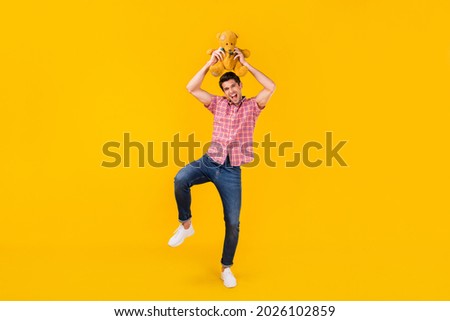 Full length body size view of nice carefree cheerful funky guy dancing with toy fooling isolated over bright yellow color background