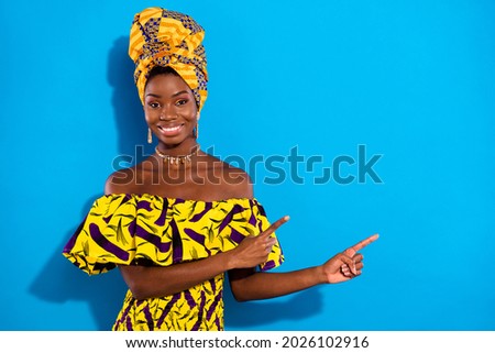 Photo of young beautiful smiling cheerful african woman advertising product isolated on blue color background