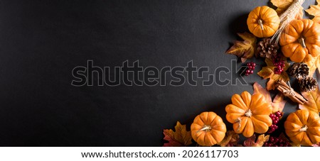 Autumn background decoration from dry leaves and pumpkin on dark wooden background. Flat lay, top view for Autumn, fall, Thanksgiving concept. Royalty-Free Stock Photo #2026117703