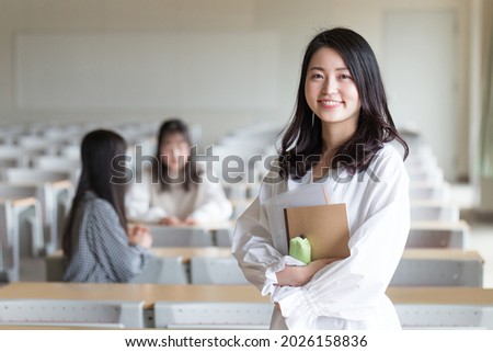 Portrait of a college student standing in a lecture room
