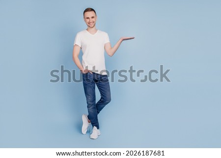Photo of attractive handsome guy holding cool offer shopping product advert advice isolated blue color background