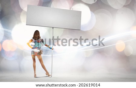 Rear view of young attractive woman with blank white banner