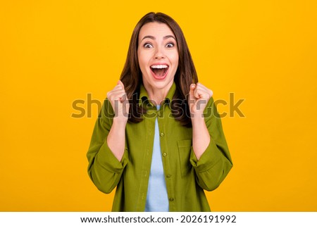 Photo of funny young lady hands fists yell wear green shirt isolated on yellow color background
