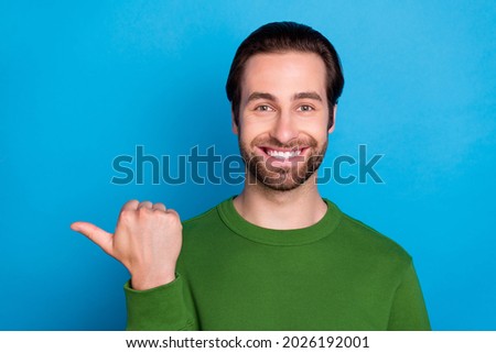 Portrait of candid friendly person toothy smile indicate thumb empty space isolated on blue color background