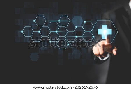 Businessman hand touching a plus sign icon.Concept of health and medical treatment.