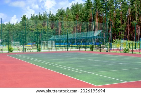 Sports ground on the outskirts of the city in a wooded area. View of the tennis court, fitness equipment, football field and others public sports grounds for team games of sport. Royalty-Free Stock Photo #2026195694
