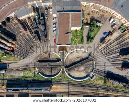 Close up aerial photo from the top of semicircular railway depot. Near two round railway turntables for turning wagons. Drone photoshot. Cargo transportation and railroad concept.