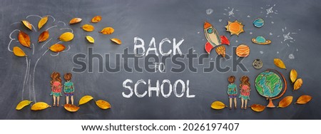 Back to school concept. Top view banner of boy and girl next to tree sketch with autumn dry leaves over classroom blackboard background