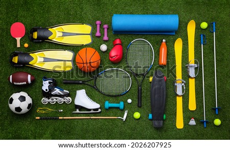 Different sport equipment on green grass, flat lay