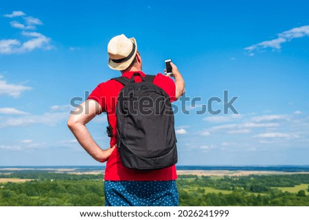 Young backpacker man taking selfie picture using smartphone.cloudy sky weather mountain summer range.Landscape summer background.Active sport backpacking healthy lifestyle concept.