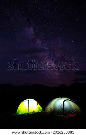 Starry night sky in the mountains with the tent