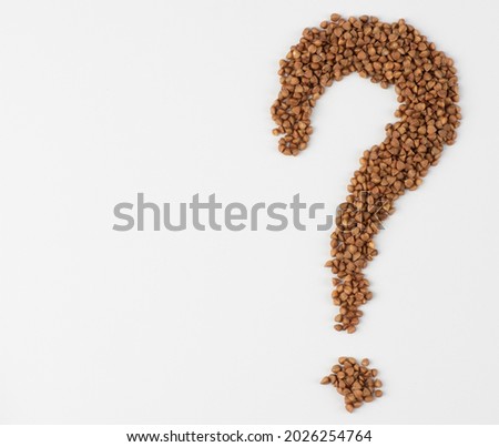 Question mark in buckwheat seeds. Buckwheat groats, question mark shaped, close up, isolated. Gluten free and non-allergenic healthy diet food. Used as source of Vegetarian Protein and improved heart  Royalty-Free Stock Photo #2026254764