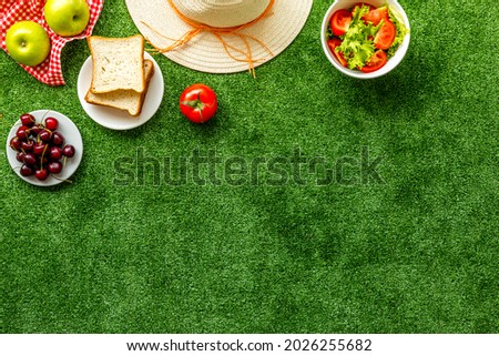 Flat lay of picnic setting with basket and summer food on red cloth