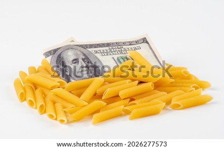 American money and Pasta on a white background. The concept of rising food prices and deficien . Restricting the export of food products. Typeface for grocery products store. Food and finance Royalty-Free Stock Photo #2026277573