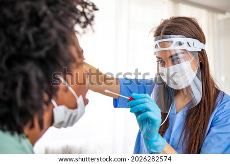 Close-up of healthcare worker taking PCR test at medical clinic. Close-up of doctor using cotton swab while doing coronavirus PCR test at the hospital. Nurse inserting the swab into the woman nostril 