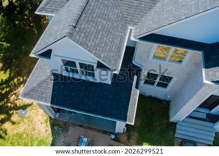 Rooftop in a new home constructed showing asphalt shingles multiple roof lines with aerial view Royalty-Free Stock Photo #2026299521